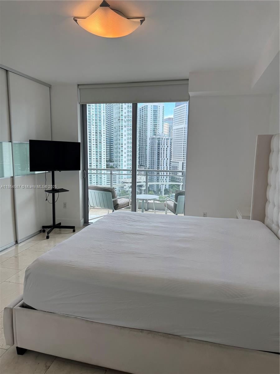 90 Southwest 3rd Street, Unit 2103 Miami, FL 33130 - Photo 15 of 31 a bedroom with a large bed and a large window