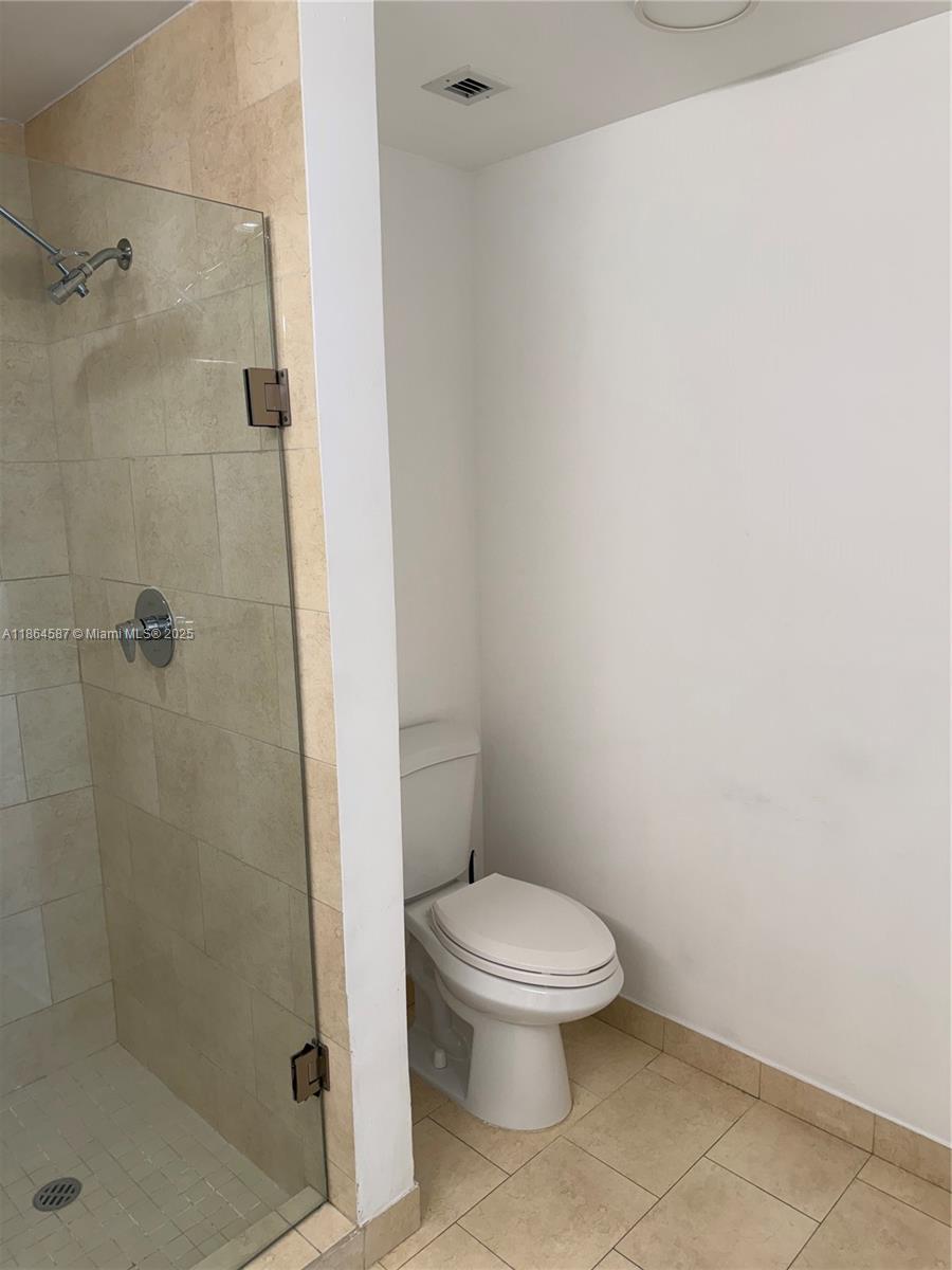 90 Southwest 3rd Street, Unit 2103 Miami, FL 33130 - Photo 21 of 31 a white toilet sitting next to a bathroom sink