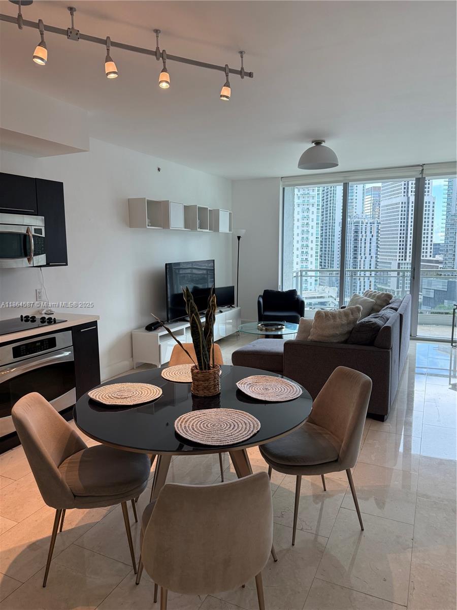 90 Southwest 3rd Street, Unit 2103 Miami, FL 33130 - Photo 5 of 31 a kitchen with stainless steel appliances kitchen island granite countertop a table and chairs