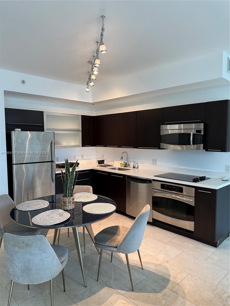 90 Southwest 3rd Street, Unit 2103 Miami, FL 33130 - Photo 9 of 31 a kitchen with a stove a refrigerator and a dining table