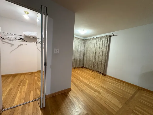 a view of walk in closet with wooden floor