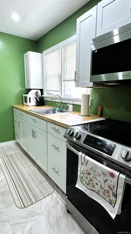 a kitchen with a sink a stove and cabinets
