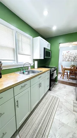 a large kitchen with stainless steel appliances granite countertop a sink and cabinets