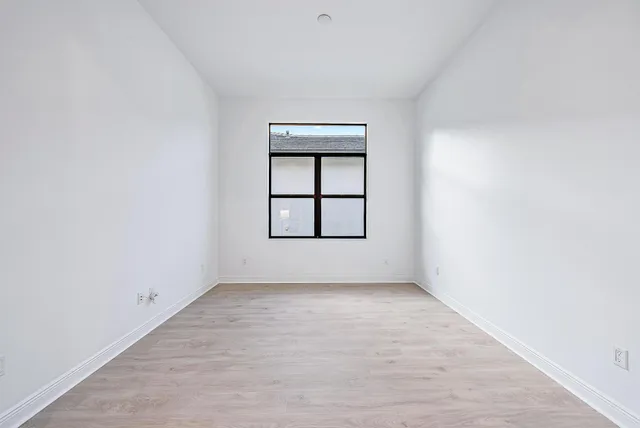 an empty room with windows and closet