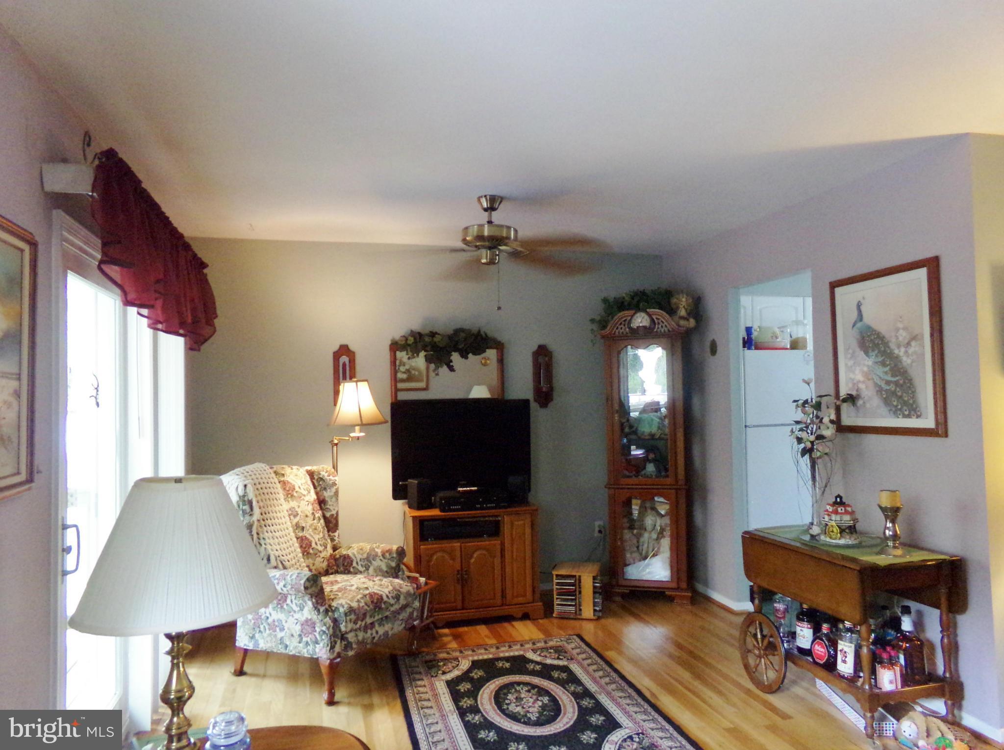 8113 Phirne Road East Glen Burnie, MD 21061 - Photo 8 of 27 a living room with furniture a flat screen tv and a lamp