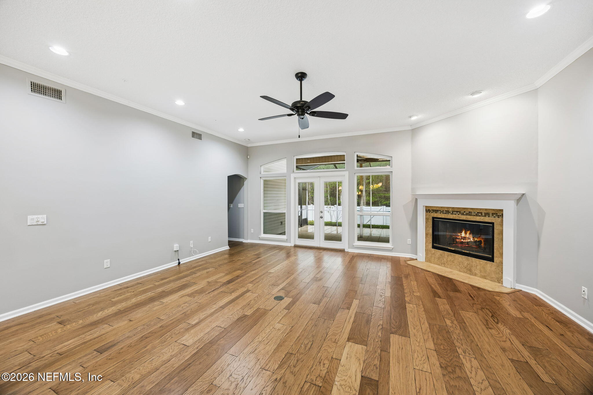 213 Springwood Lane St. Johns, FL 32259 - Photo 25 of 78 an empty room with fireplace wooden floor and a chandelier