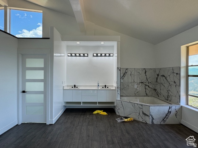 6909 East Spring Drive, Unit 19 Springville, UT 84663 - Photo 27 of 118 Spacious bathroom featuring a built-in tub with marble-patterned tile surround, dual vanity with modern cabinetry, wood-finish flooring, and a contemporary door with frosted glass panels
