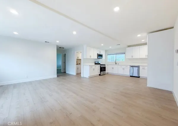 a view of a kitchen with a sink and a refrigerator in it