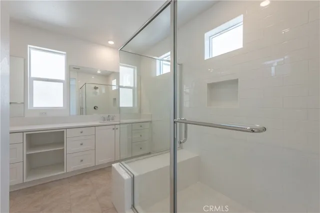 a bathroom with white cabinets and sink
