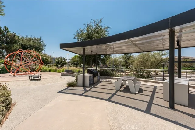 a view of swimming pool that has lawn chairs with plants