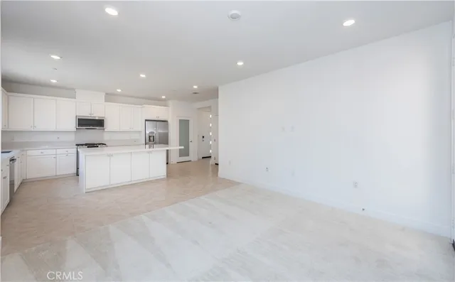 a kitchen that has a sink a refrigerator and cabinets
