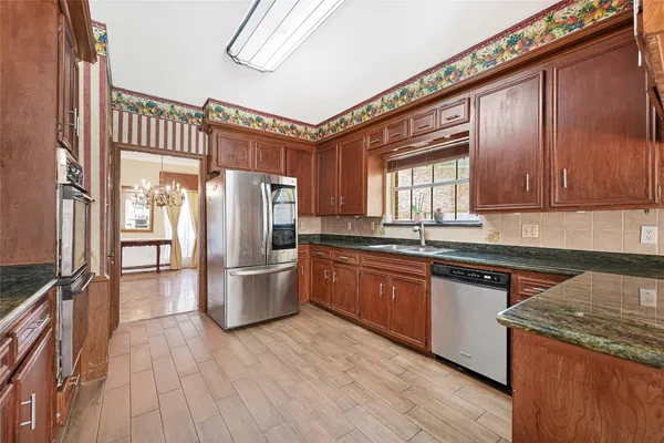 a kitchen with stainless steel appliances granite countertop a stove cabinets and wooden floor