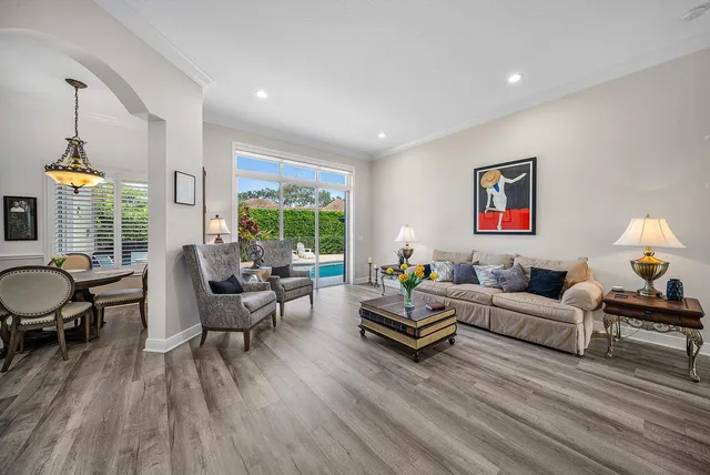 a kitchen with stainless steel appliances granite countertop a stove a sink dishwasher a refrigerator and white cabinets with wooden floor