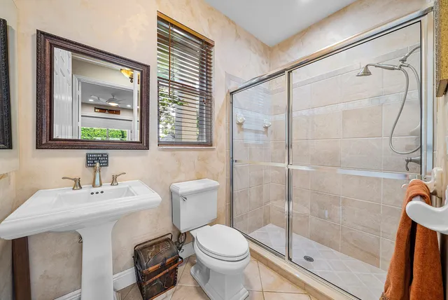 a view of a house with pool lawn chairs and floor to ceiling window