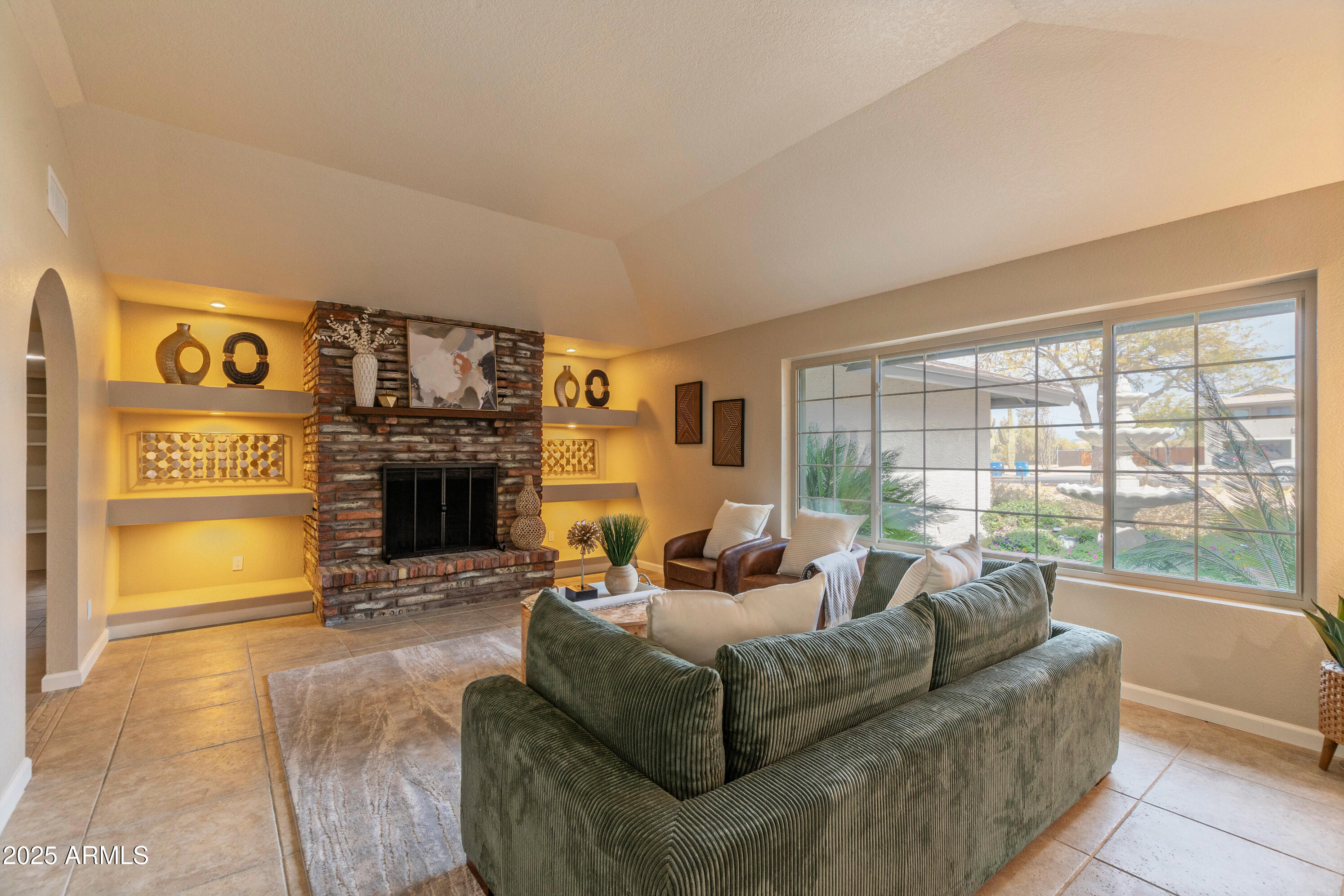 5911 East Peak View Road Cave Creek, AZ 85331 - Photo 11 of 63 a living room with furniture a large window and a fireplace