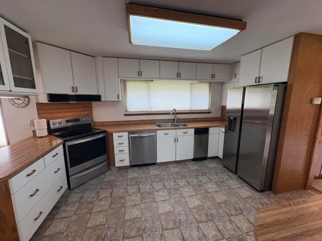 a kitchen with stainless steel appliances granite countertop a stove a sink and a refrigerator