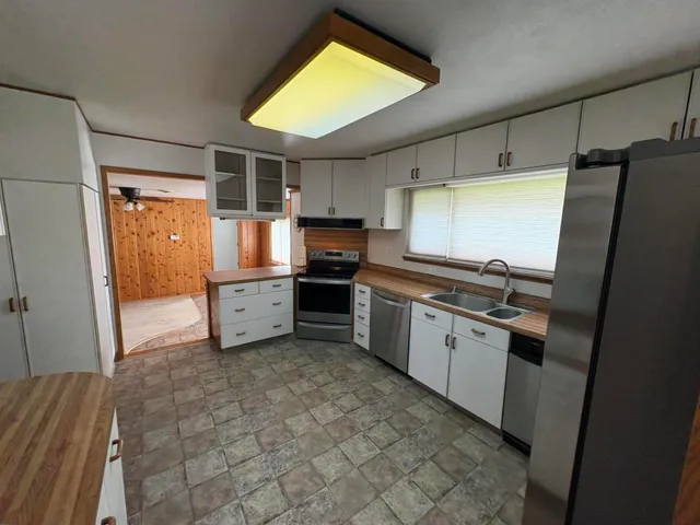 a kitchen with stainless steel appliances a refrigerator sink and cabinets