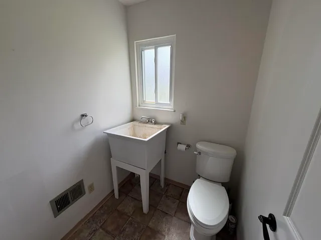 a white toilet sitting next to a bathroom sink