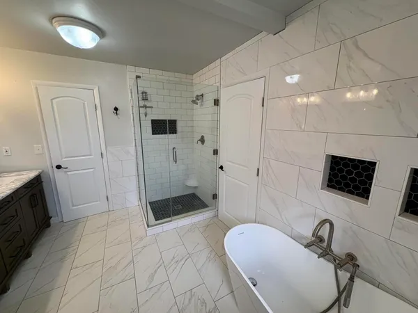 a bathroom with a sink a toilet a mirror and shower