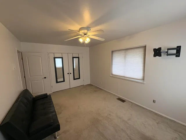 a view of an empty room with a ceiling fan