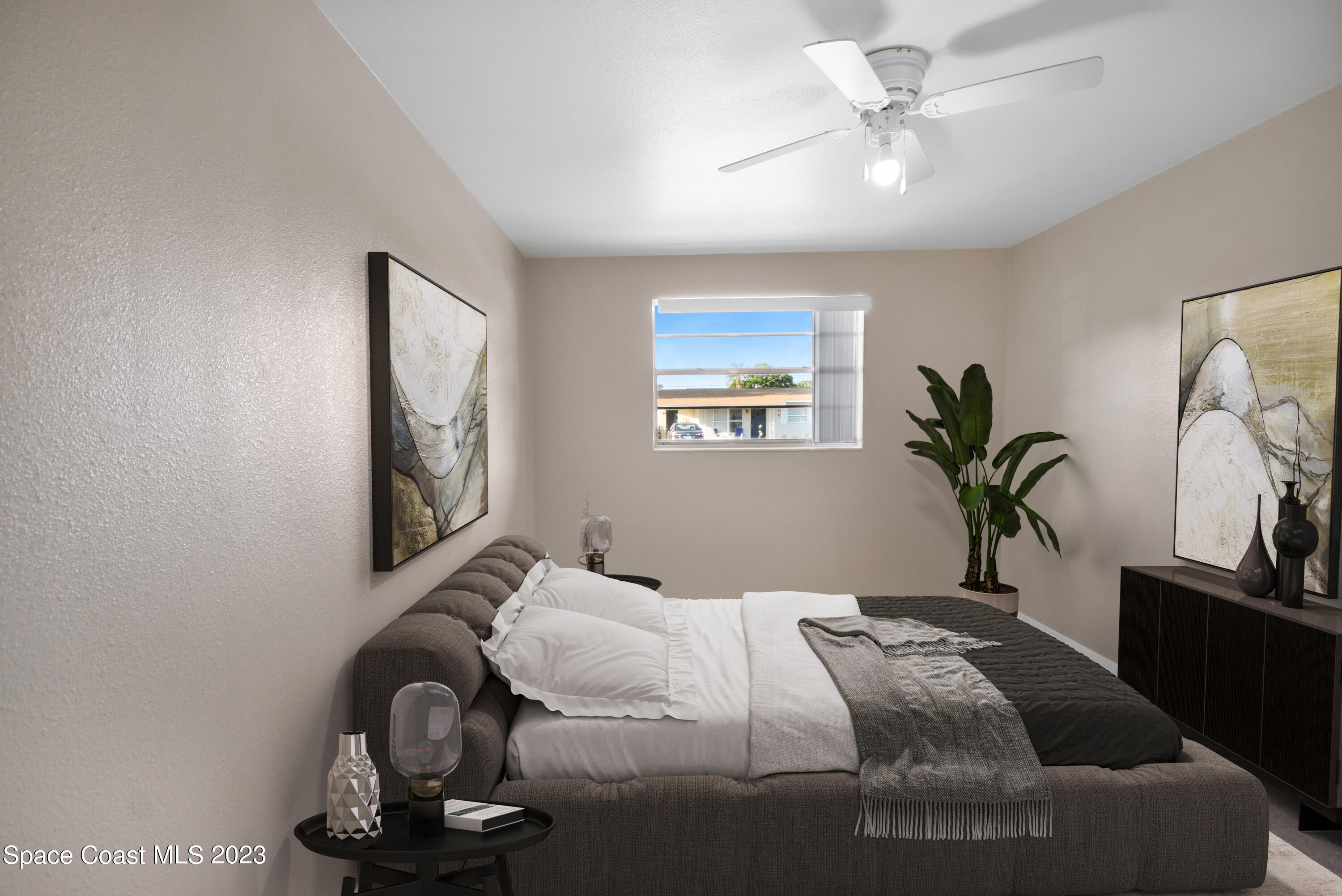 2439 Delaware Drive Melbourne, FL 32935 - Photo 12 of 32 a bedroom with a bed and a chandelier