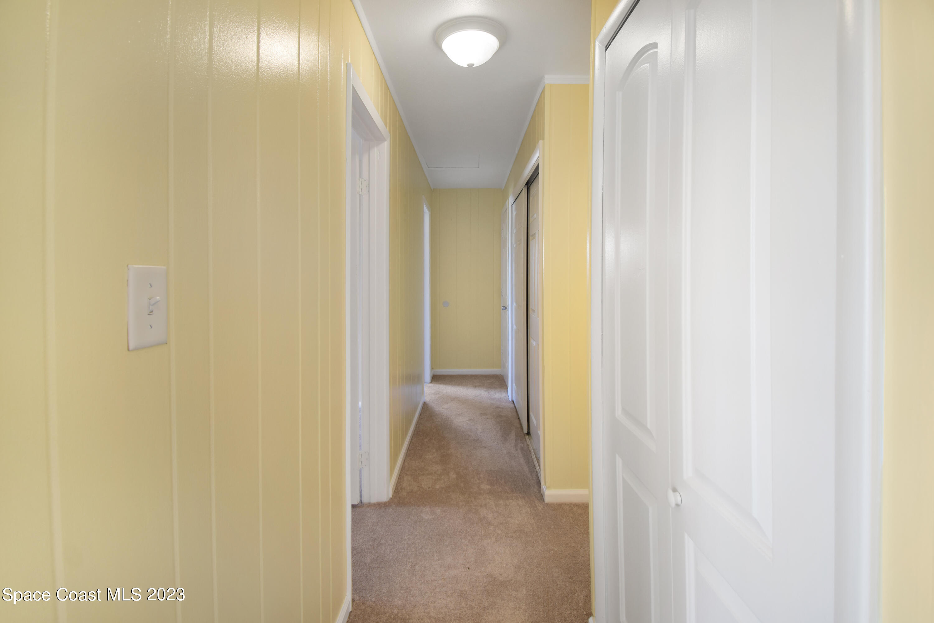 2439 Delaware Drive Melbourne, FL 32935 - Photo 15 of 32 a view of a hallway with wooden floor
