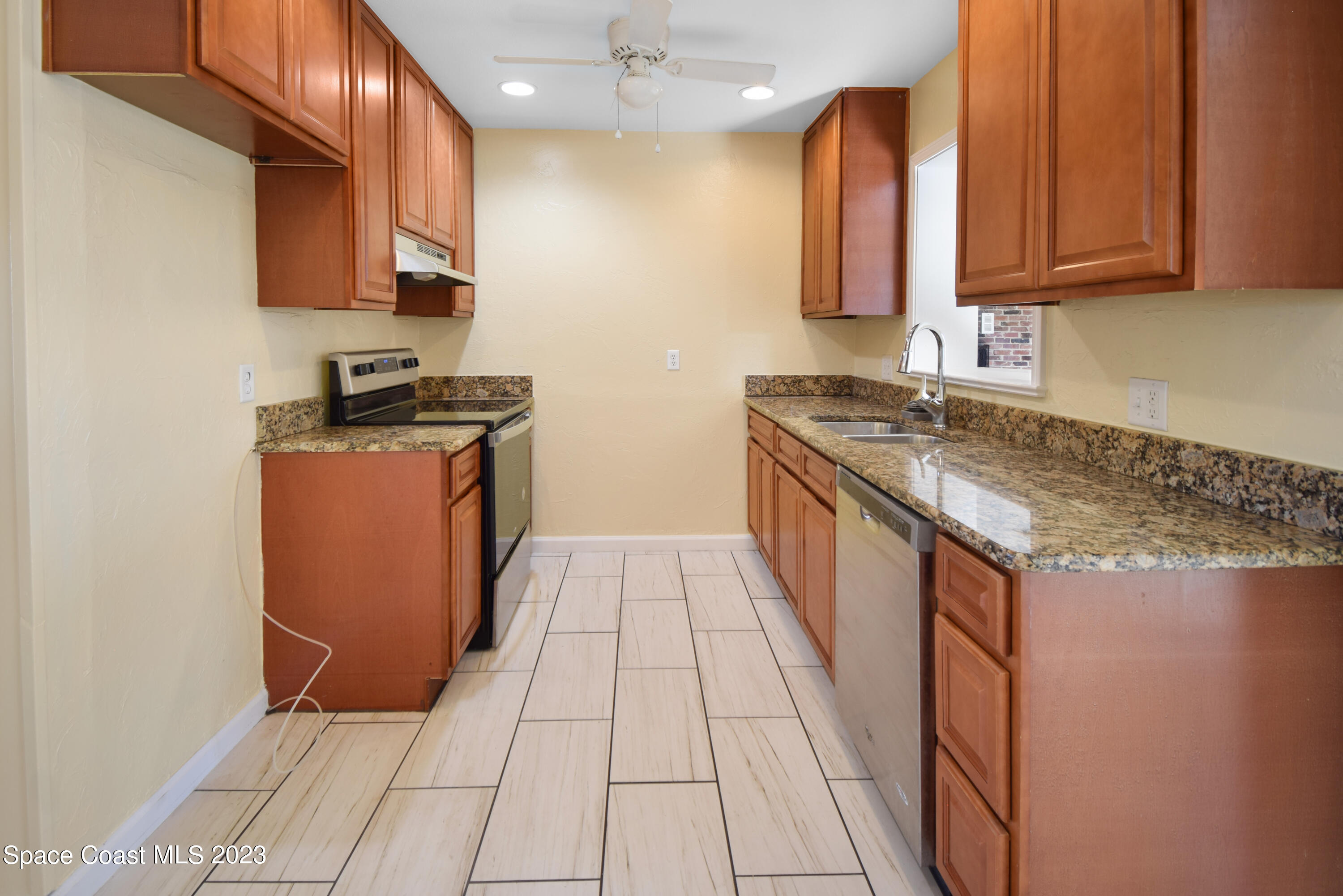 2439 Delaware Drive Melbourne, FL 32935 - Photo 18 of 32 a kitchen with stainless steel appliances granite countertop a stove a sink and a microwave