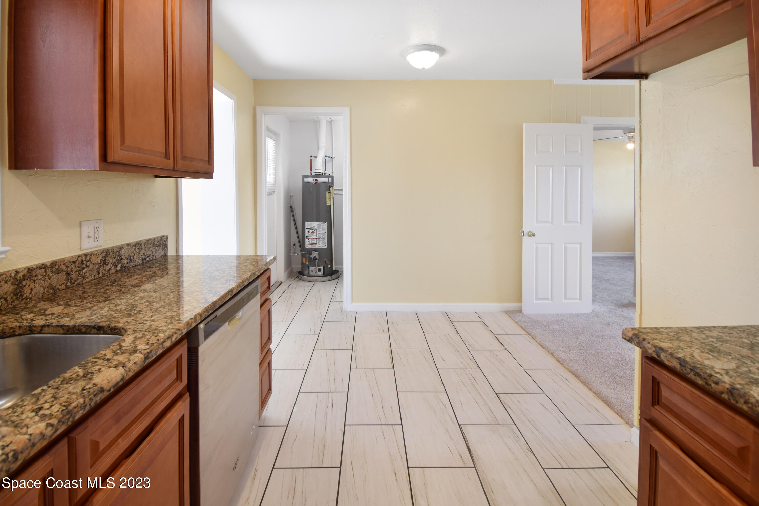 2439 Delaware Drive Melbourne, FL 32935 - Photo 21 of 32 a kitchen with granite countertop a sink stove and cabinets