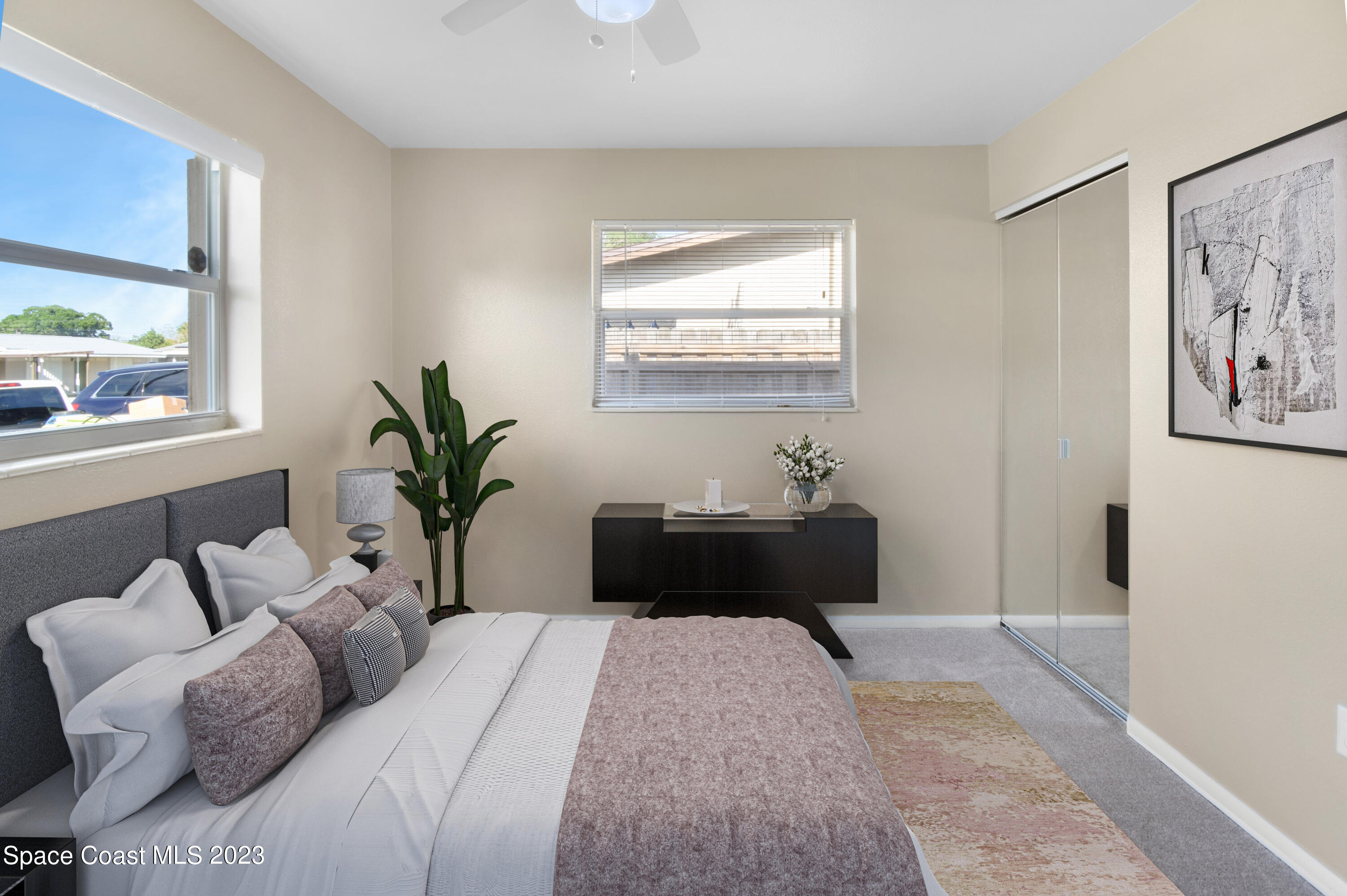 2439 Delaware Drive Melbourne, FL 32935 - Photo 10 of 32 a bedroom with a bed lamp and a potted plant