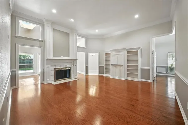 an empty room with wooden floor and fireplace