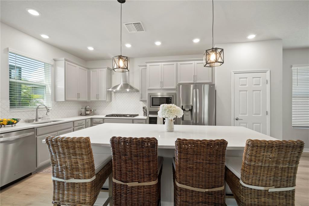 5636 Silver Sun Drive Apollo Beach, FL 33572 - Photo 25 of 61 a kitchen with stainless steel appliances kitchen island granite countertop a dining table chairs and sink