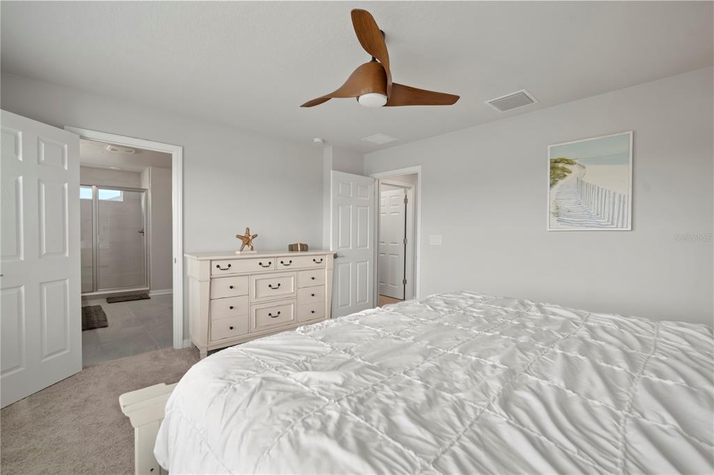 5636 Silver Sun Drive Apollo Beach, FL 33572 - Photo 40 of 61 a spacious bedroom with a bed and a chandelier