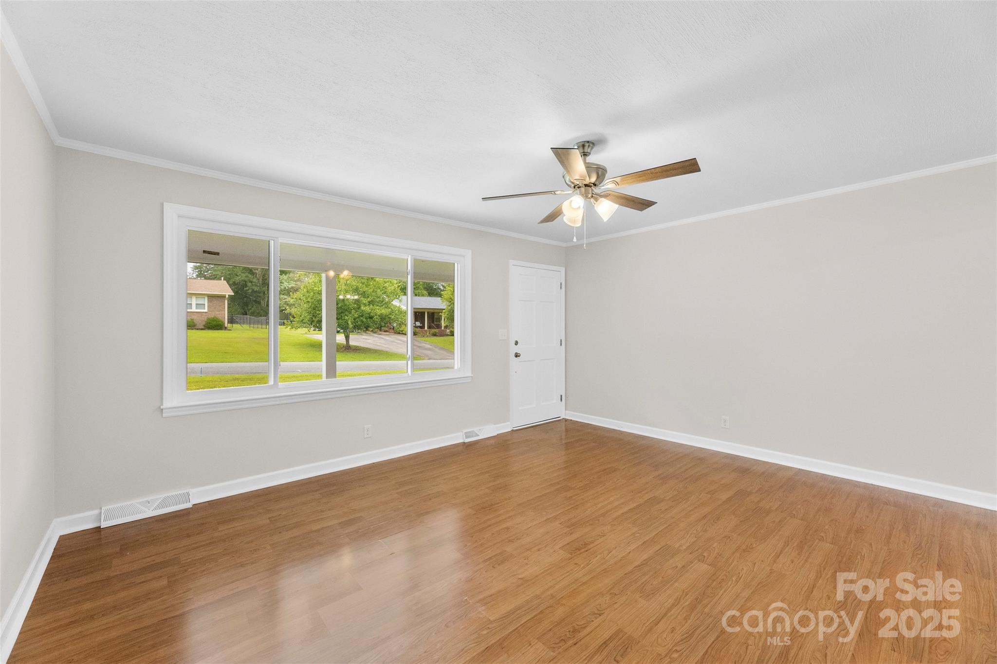 404 Kings Street Cherryville, NC 28021 - Photo 6 of 33 an empty room with a window and a ceiling fan