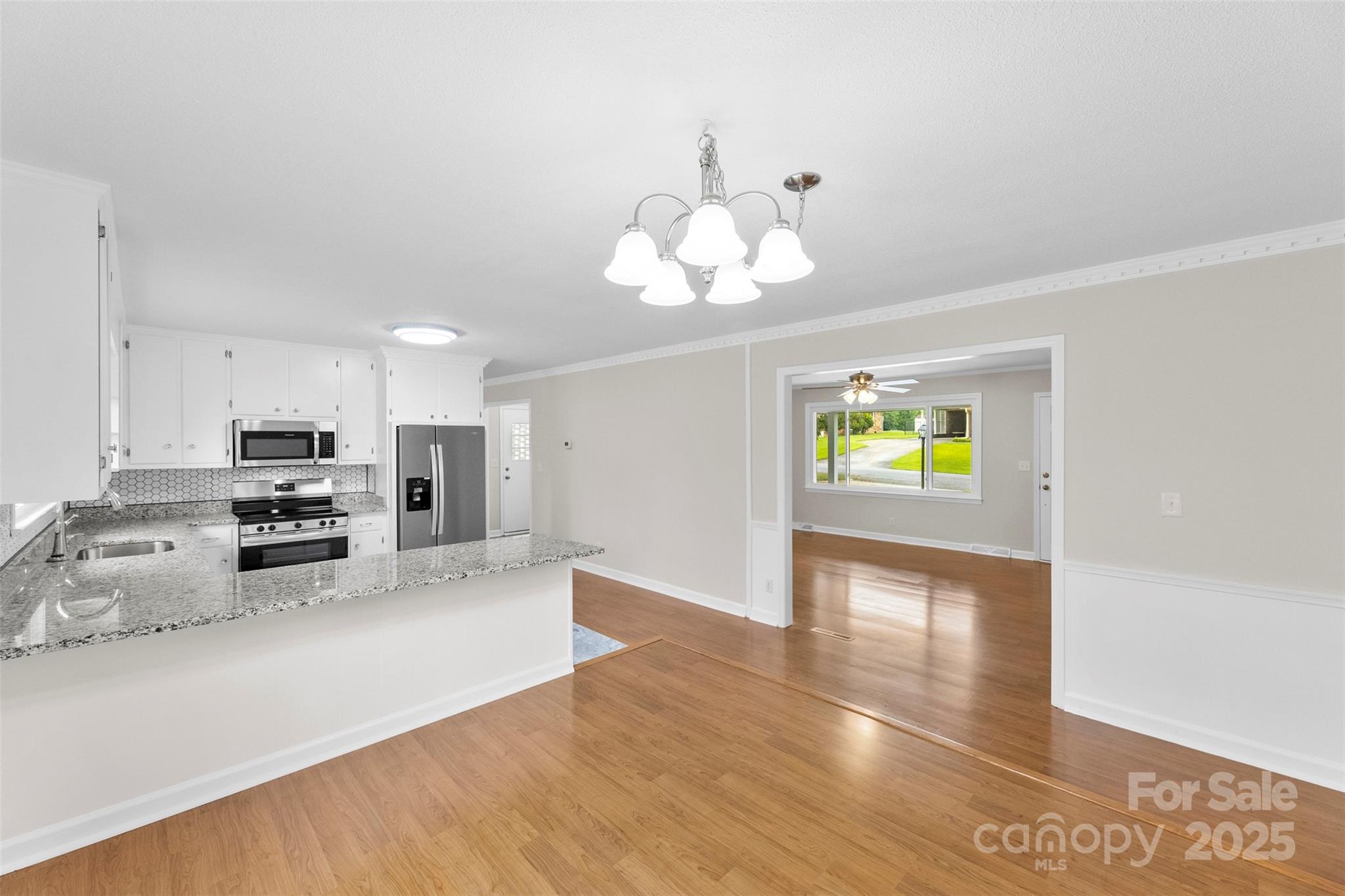 404 Kings Street Cherryville, NC 28021 - Photo 9 of 33 a view of a kitchen with kitchen island stainless steel appliances microwave stove refrigerator and wooden floor