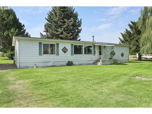 a front view of house with yard and trees