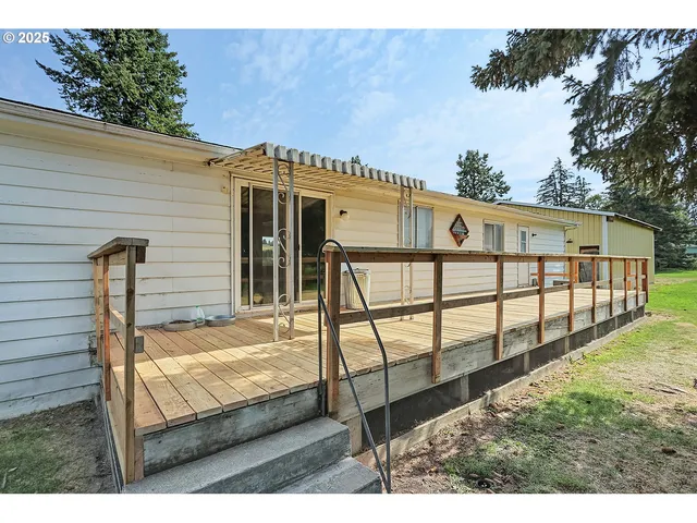 a view of a house with backyard and deck