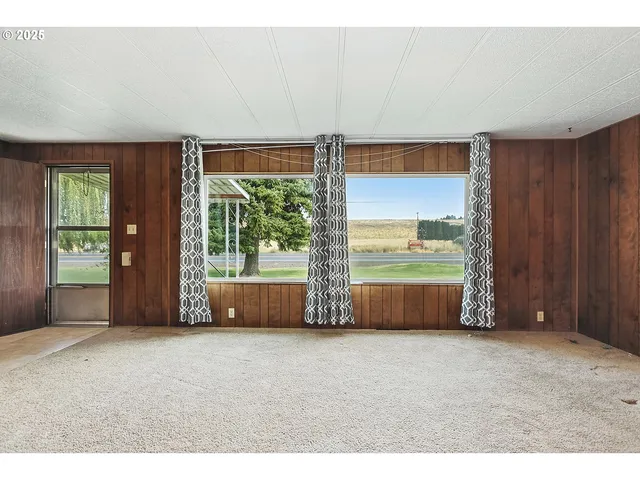 a living room with furniture and large windows
