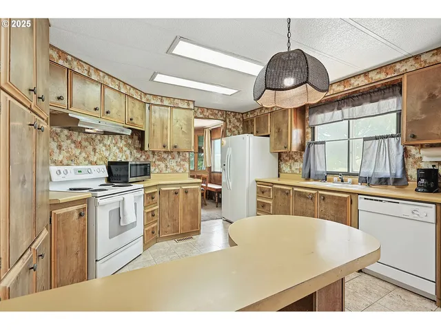 a kitchen with stainless steel appliances granite countertop a sink a stove and refrigerator