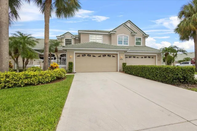 a front view of a house with a garden and palm tree
