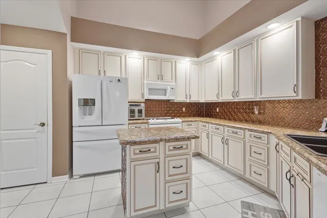 a kitchen with granite countertop cabinets stainless steel appliances and a counter space