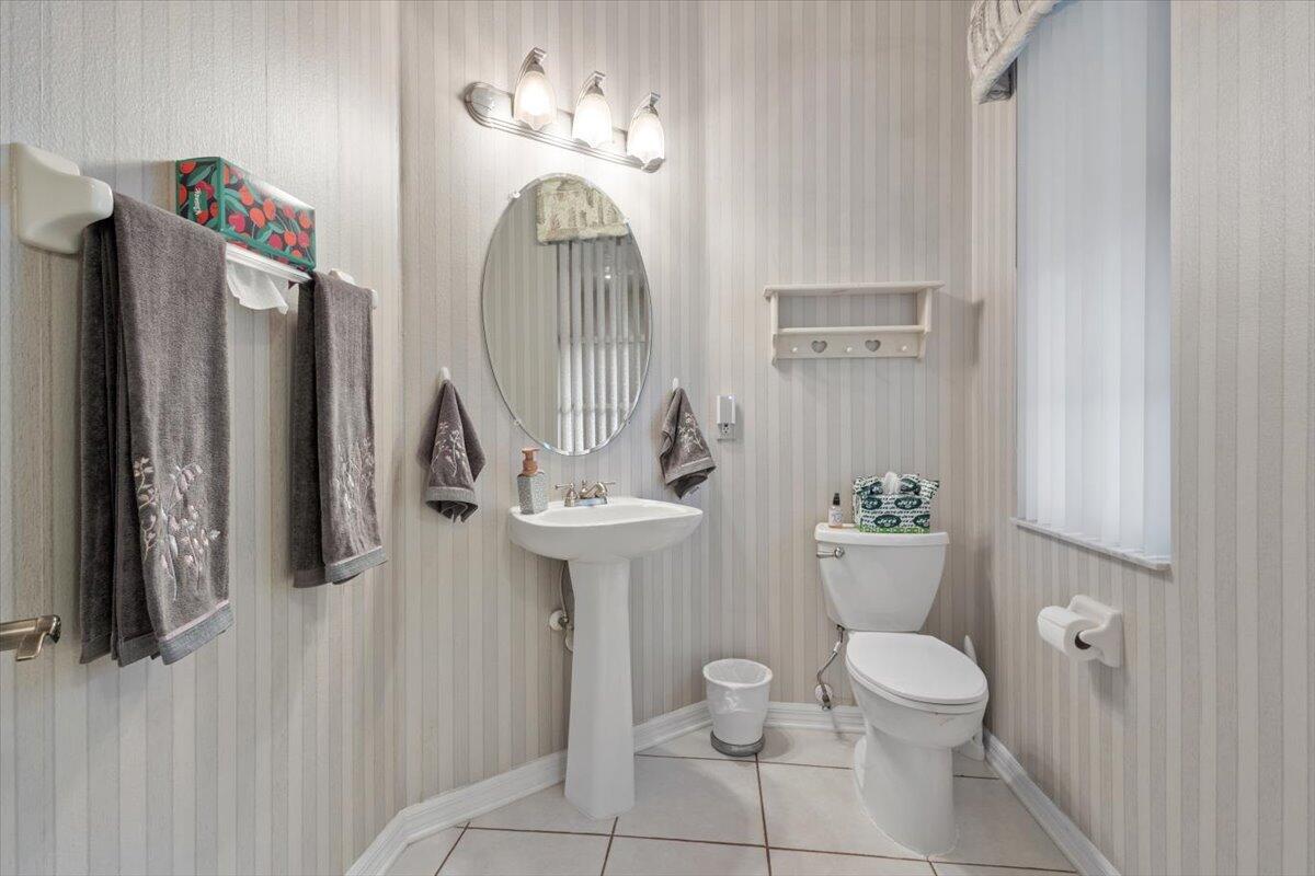 1634 Southwest Harbour Isles Circle, Unit 89 Port St. Lucie, FL 34986 - Photo 28 of 71 a bathroom with a sink a toilet and a mirror