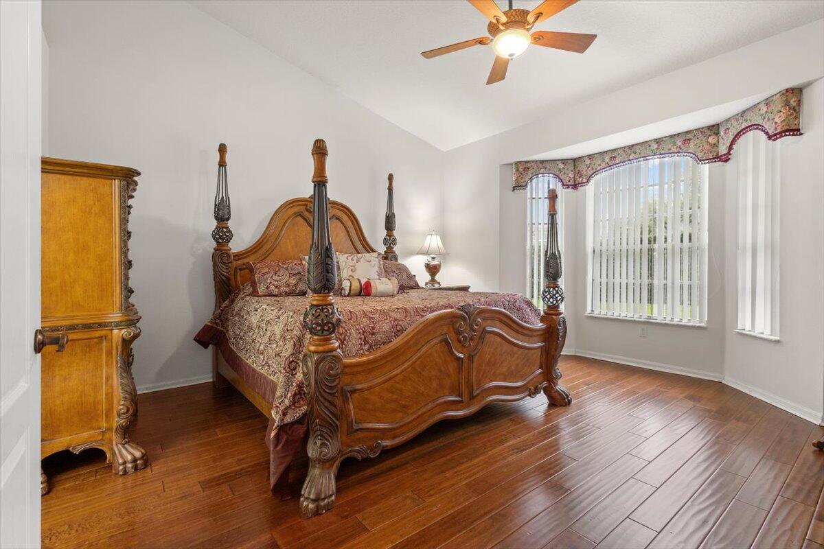 1634 Southwest Harbour Isles Circle, Unit 89 Port St. Lucie, FL 34986 - Photo 30 of 71 a bedroom with a bed and a chandelier