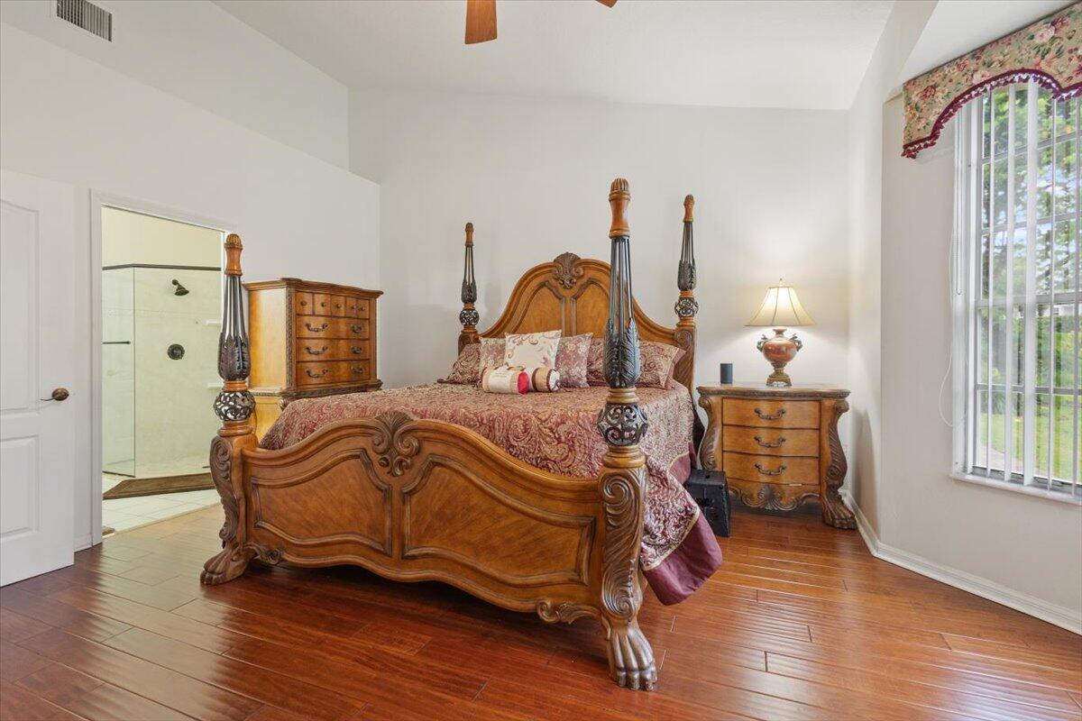 1634 Southwest Harbour Isles Circle, Unit 89 Port St. Lucie, FL 34986 - Photo 31 of 71 a bedroom with a bed and wooden floor