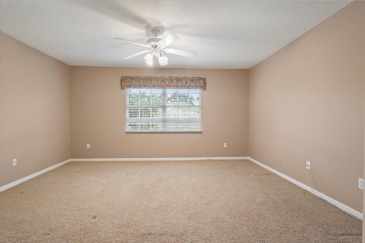 1634 Southwest Harbour Isles Circle, Unit 89 Port St. Lucie, FL 34986 - Photo 44 of 71 an empty room with windows and chandelier fan