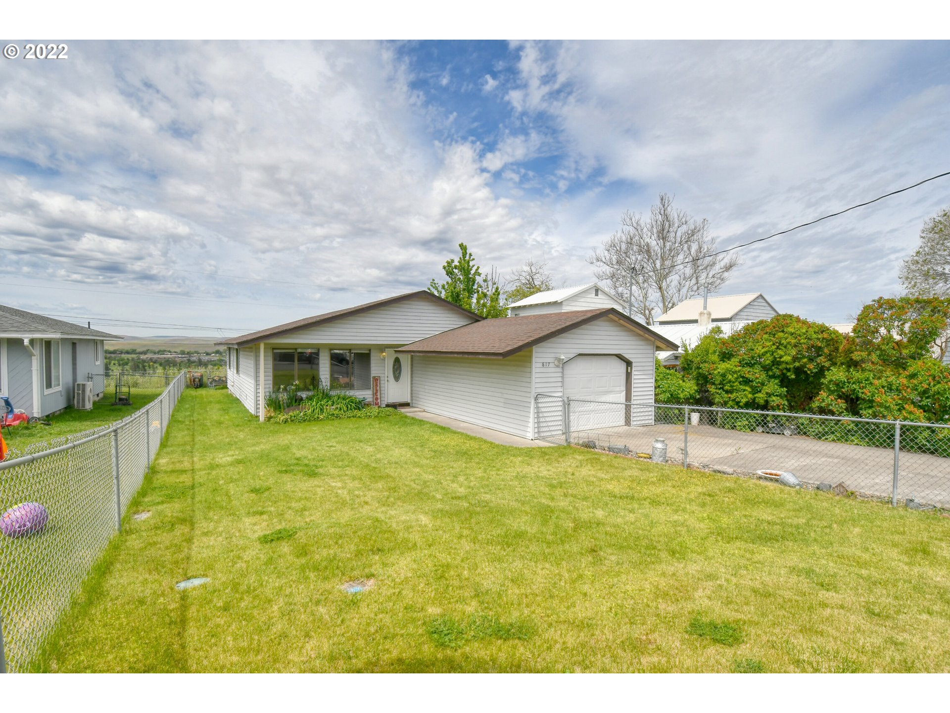 817 Southwest 10th Street Pendleton, OR 97801 - Photo 1 of 25 a yellow house with a big yard and large trees