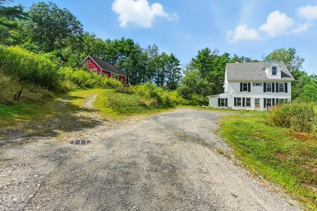 a view of a house with a yard and potted plants