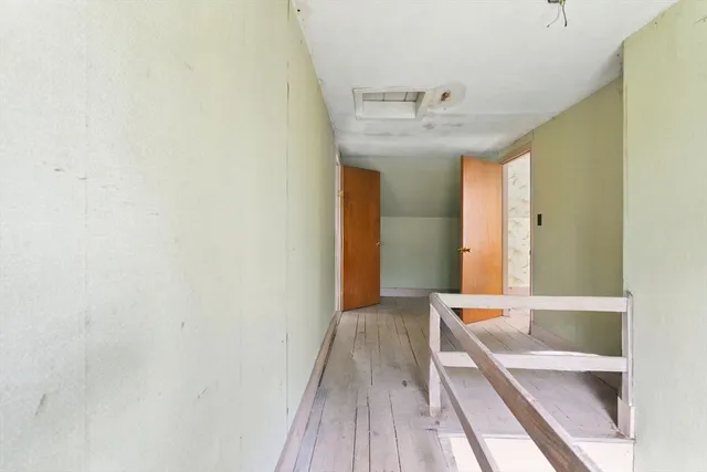 a bed sitting in a spacious bedroom next to a window