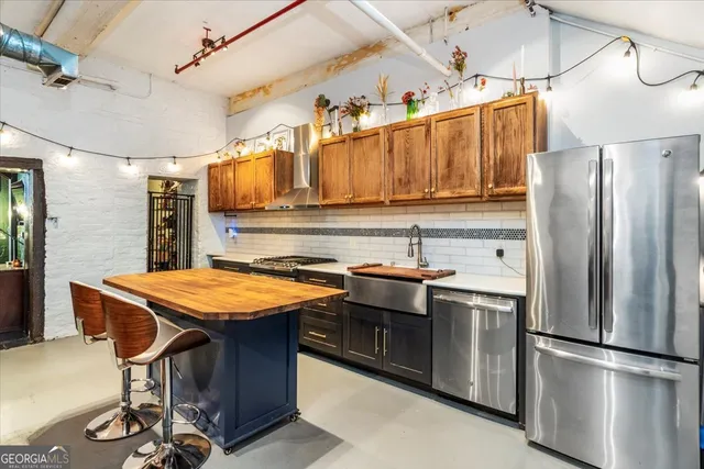 a kitchen with stainless steel appliances granite countertop a sink refrigerator and cabinets