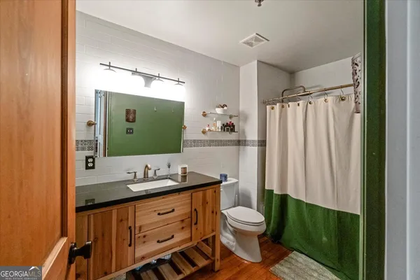 a bathroom with a double vanity sink toilet and mirror