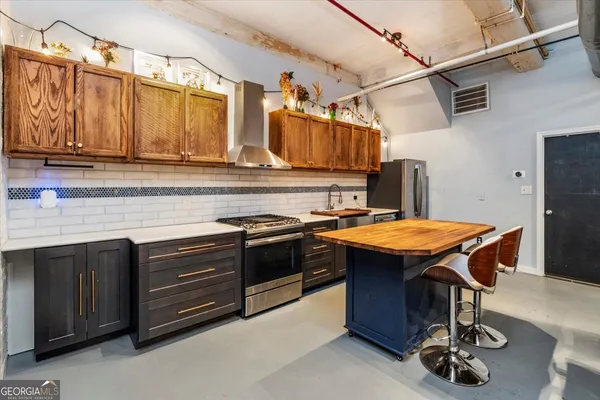 a kitchen with stainless steel appliances granite countertop a stove a sink dishwasher and cabinets with wooden floor